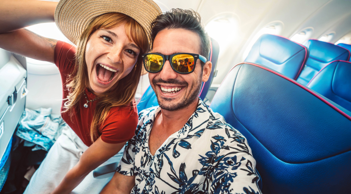 Una familia multi-generacional disfruta de un momento feliz caminando juntos por una playa soleada, simbolizando los 20 años de servicio de Condal Viajes en unir familias entre España y Latinoamérica a través de viajes significativos y experiencias culturales enriquecedoras.